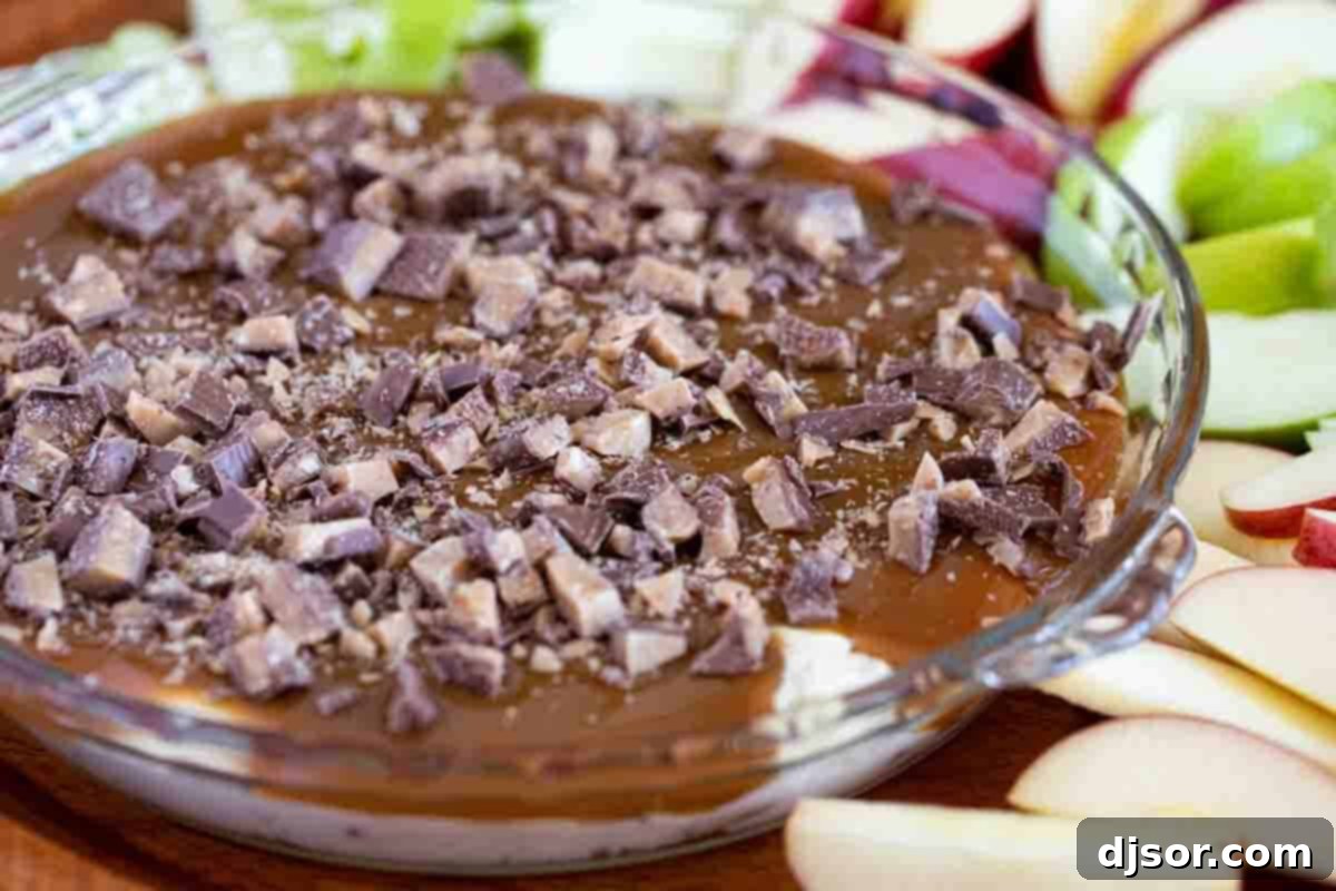 A stunning Caramel Apple Dip displayed in a clear glass pie plate, garnished with toffee bits.