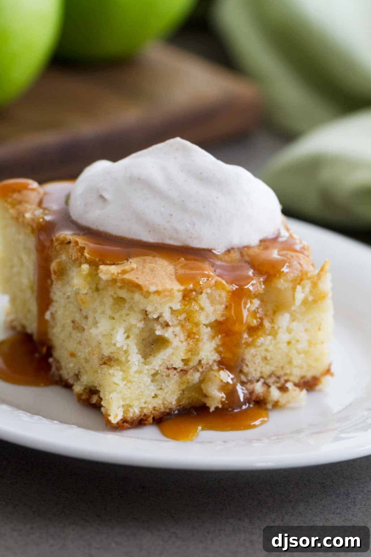 slice of apple cinnamon cake with caramel and whipped cream on a plate