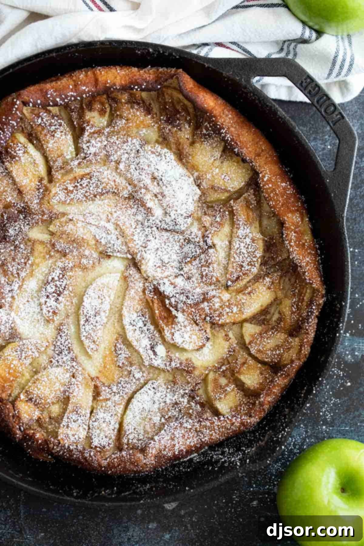 Overhead view of German Apple Pancake with apples on the side