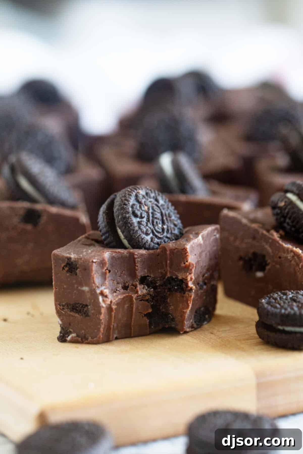 Ultimate Oreo Fudge Delight 7 A close-up of a piece of Oreo Fudge with a bite taken out, revealing the creamy interior and cookie chunks.