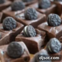 Ultimate Oreo Fudge Delight 8 Squares of Oreo Fudge topped with mini Oreo cookies, presented as a finished recipe example.