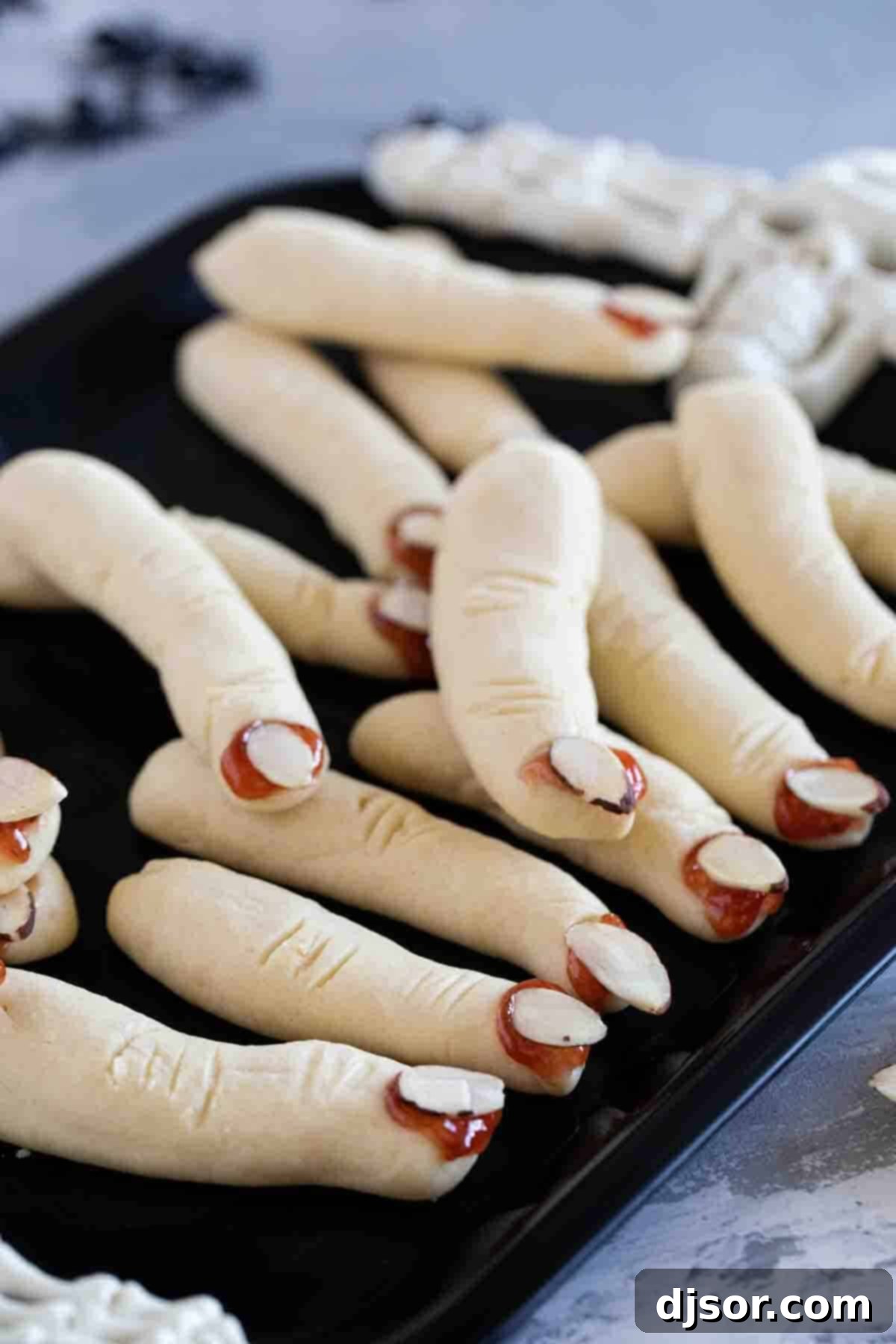 Finished Witch Finger Cookies on a Tray Witch Fingers cookies on a black tray.