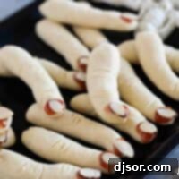 Ghoulish Digits 2 Witch Fingers cookies on a black tray.