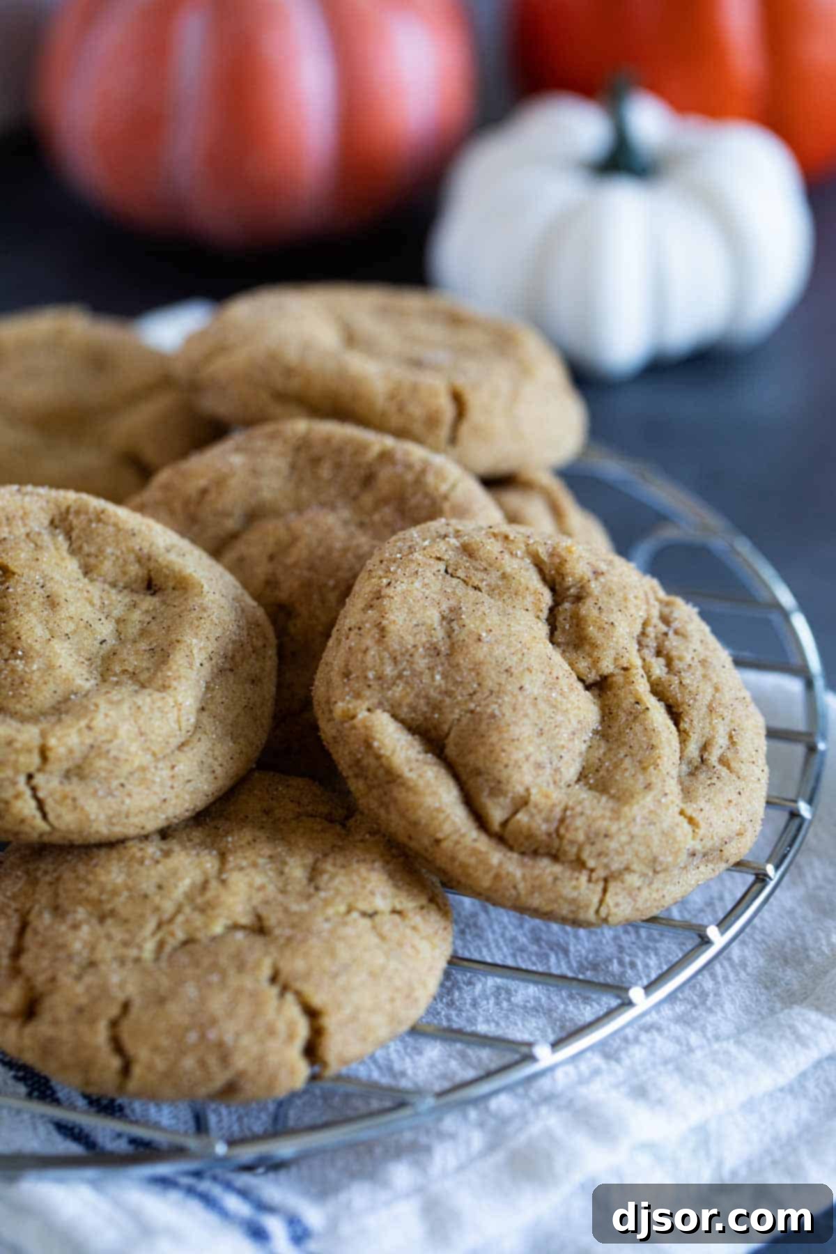 Pumpkin Snickerdoodles stacked on a cooling rack.