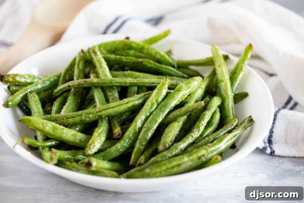 The easiest and fastest Air Fryer Green Beans recipe for a delicious and healthy side dish. A rustic bowl brimming with perfectly cooked, crisp-tender air fryer green beans, seasoned to perfection.