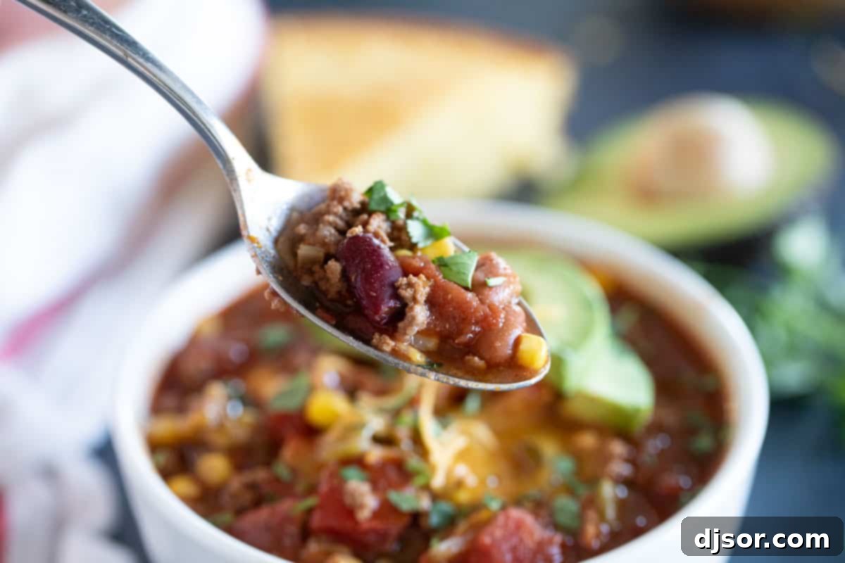 Scoop of Flavorful Taco Soup A spoon laden with rich and hearty Taco Soup, showcasing its delicious texture.