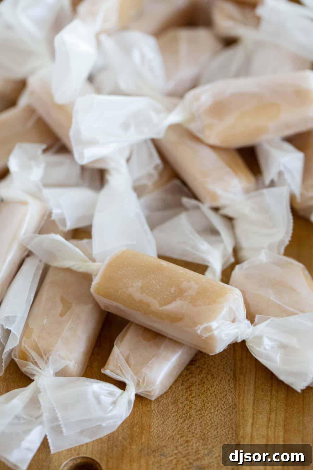 Perfect every time, these microwave caramels couldn’t get much easier! A few minutes of hands on time and you have caramel candy that tastes like you bought it at a fancy candy store. Stack of microwave caramels wrapped in wax paper.