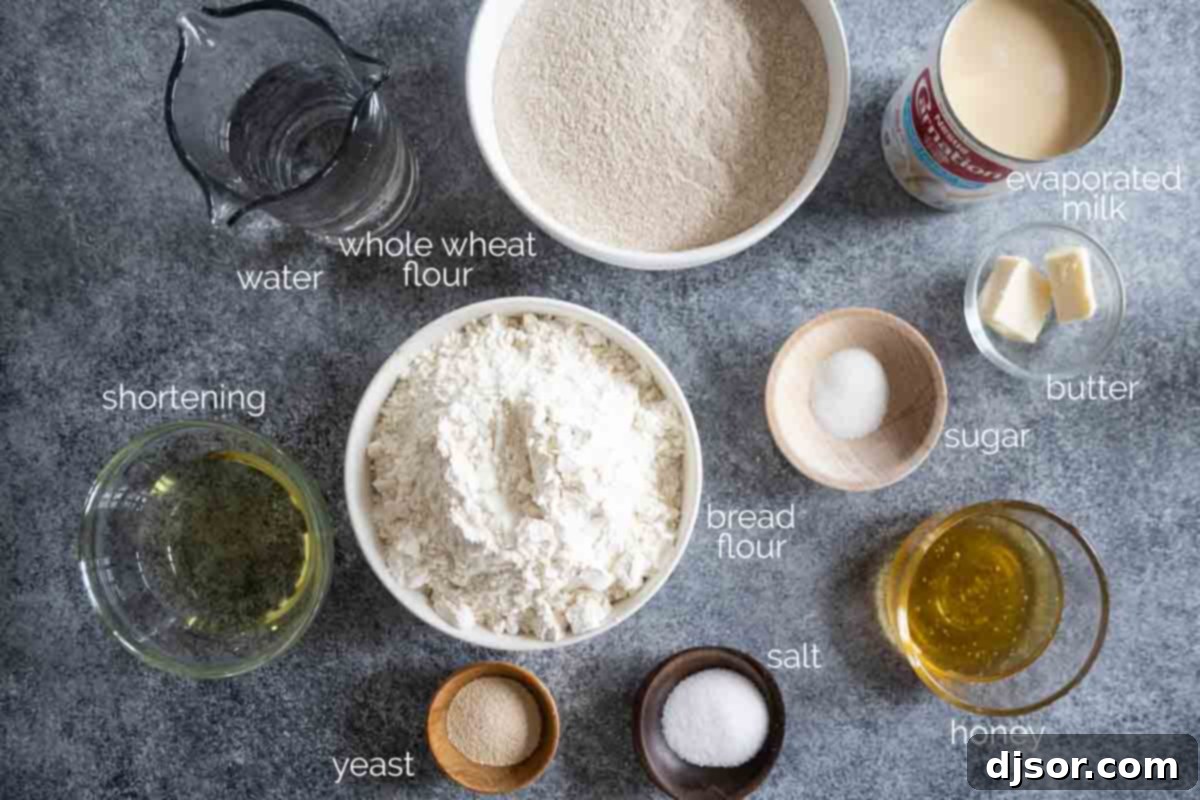 These Whole Wheat Rolls are a perfect dinner roll made with whole wheat flour and bread flour. A bit of honey brings in some sweetness, while evaporated milk brings richness to the rolls. A selection of fresh ingredients laid out on a kitchen counter, ready for making whole wheat rolls: water, yeast, sugar, evaporated milk, shortening, honey, salt, and two types of flour.
