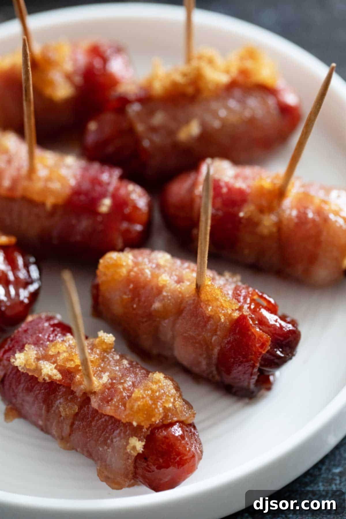 A platter of perfectly baked bacon wrapped smokies, golden and glistening with caramelized brown sugar, ready for guests.