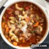 A bowl of comforting Hamburger Soup topped with grated Parmesan cheese.