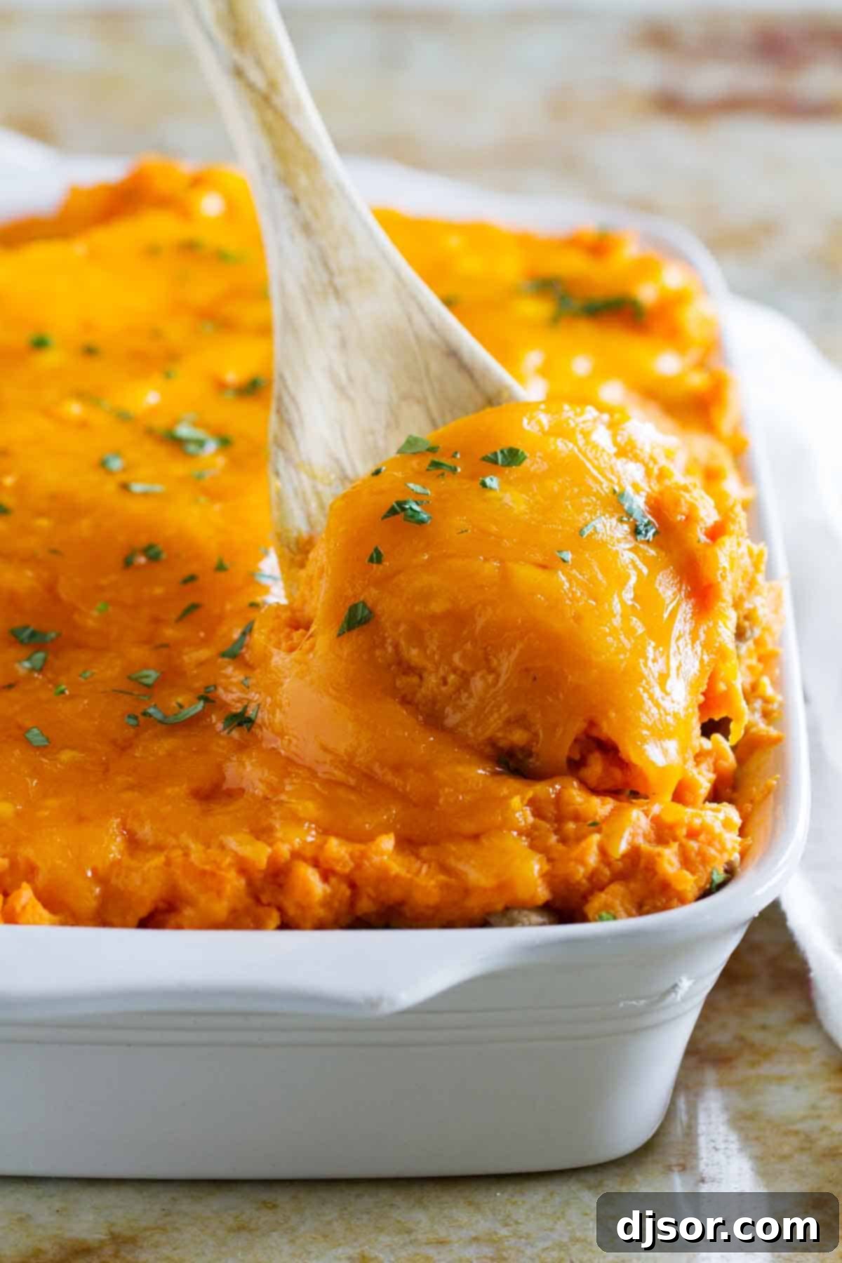 Golden Sweet Potato Topped Turkey Shepherds Pie 2 Scooping out a generous serving of Turkey Shepherd's Pie with Sweet Potatoes, highlighting its golden-brown topping and rich, savory filling.
