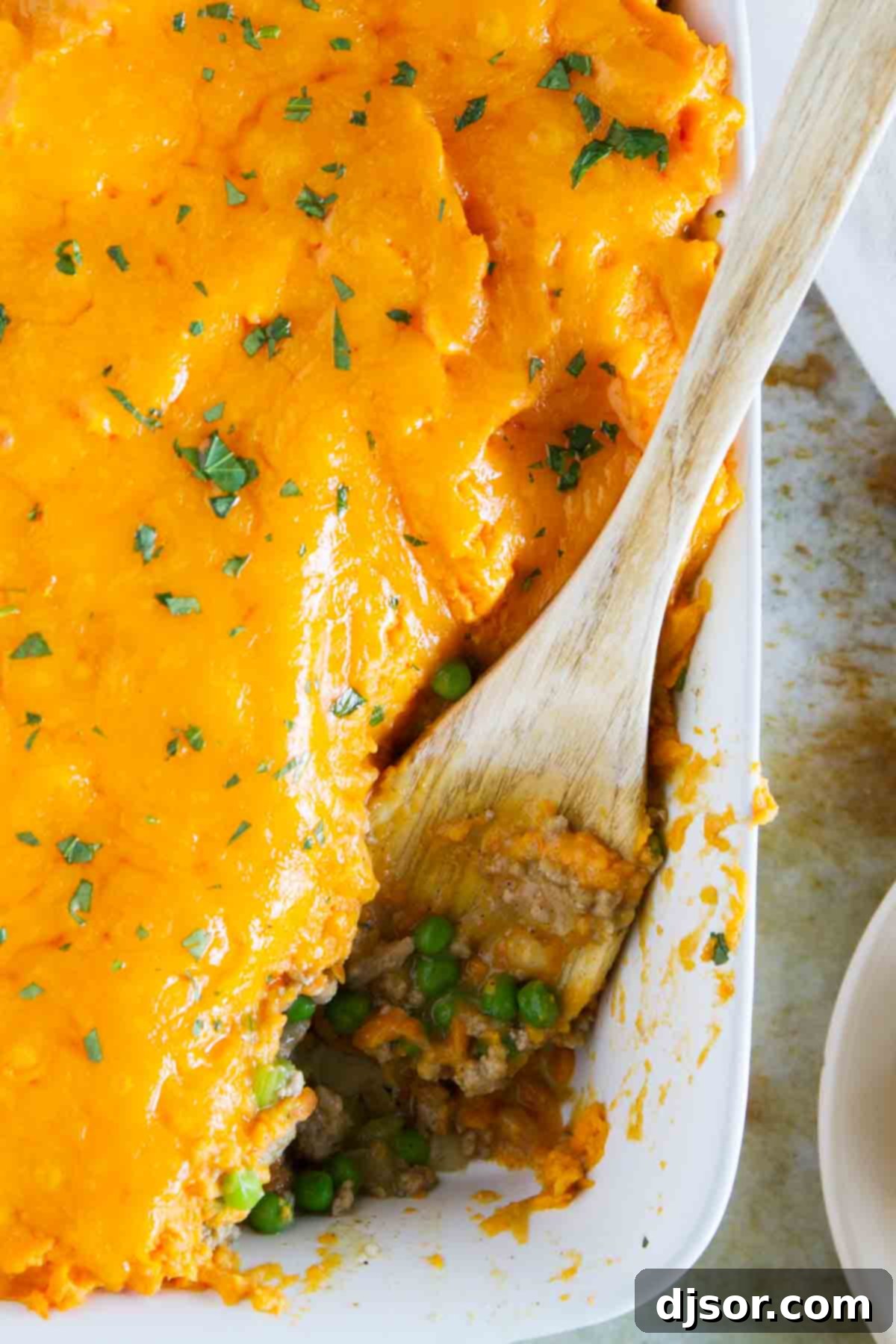 Golden Sweet Potato Topped Turkey Shepherds Pie 3 A large baking dish filled with Turkey Shepherd's Pie, showcasing a perfectly browned and bubbling sweet potato crust, ready for serving.