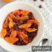 Sweet-Tart Orange Cranberry Compote 2 bowl of orange compote with candied cranberries with a serving spoon.