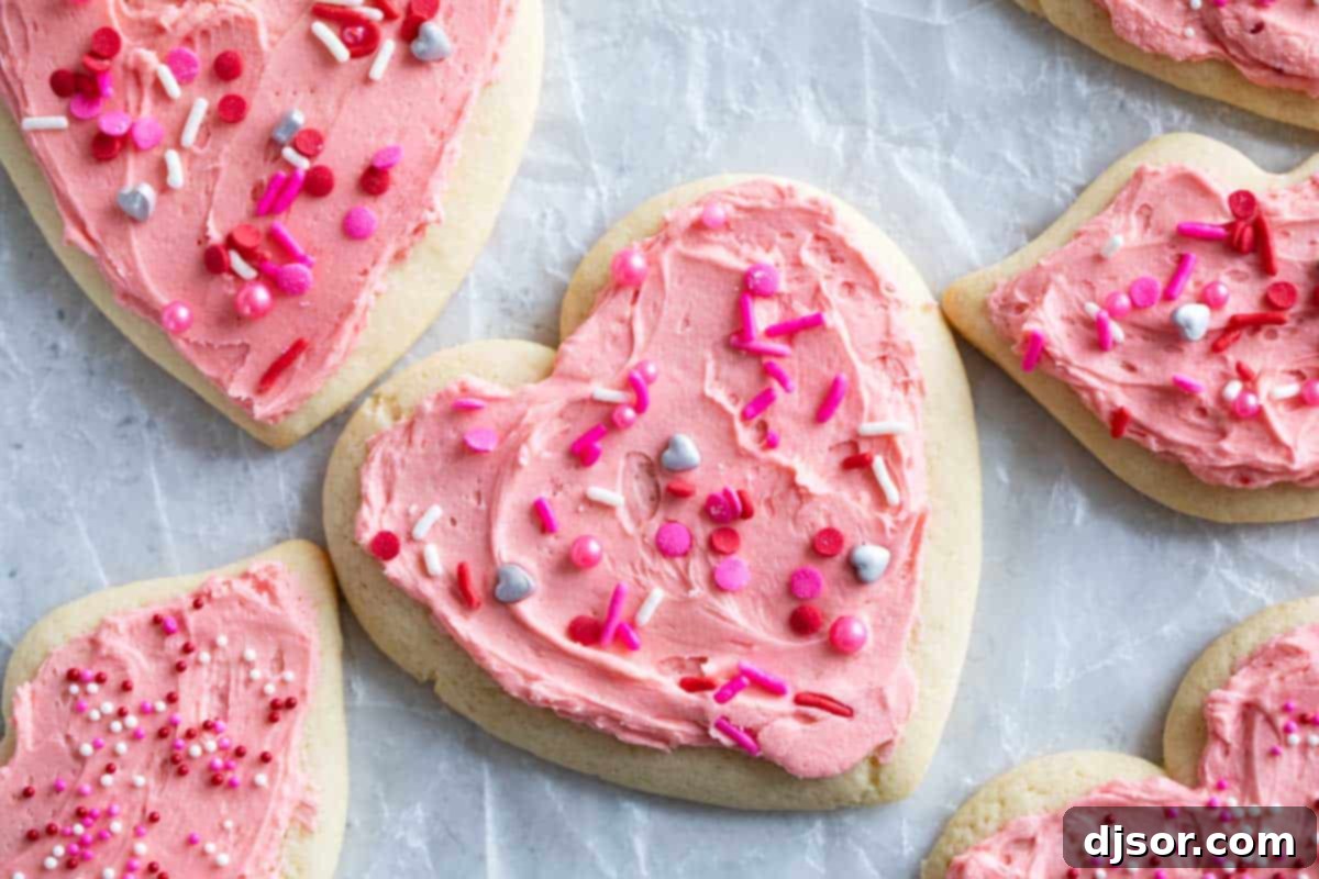 Pretty in pink, these Valentine's Day Sugar Cookies start with an easy sugar cookie recipe that is topped with the perfect pink buttercream and lots of holiday sprinkles. Valentine's Day Sugar Cookies shaped as hearts and lips, covered in pink buttercream.
