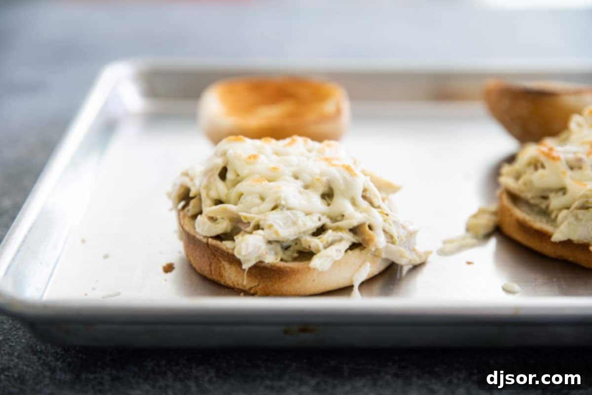A close-up of a delicious 20-minute Suizas Style Pulled Chicken Sandwich with melted cheese