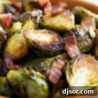 Crispy Roasted Brussels Sprouts 2 A ceramic bowl brimming with crispy, golden-brown roasted Brussels sprouts mixed with pieces of bacon.