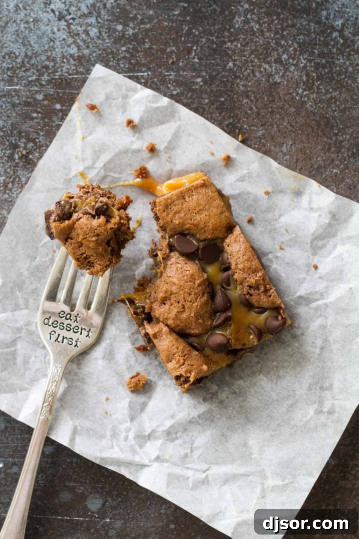 Caramel brownie with a bite taken on a fork that says eat dessert first.