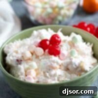 Heavenly Fruit Fluff 2 Green bowl filled with Ambrosia Salad, topped with maraschino cherries.