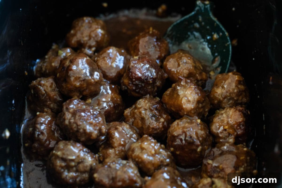 Asian meatballs coated in sauce inside a slow cooker, ready to be served.