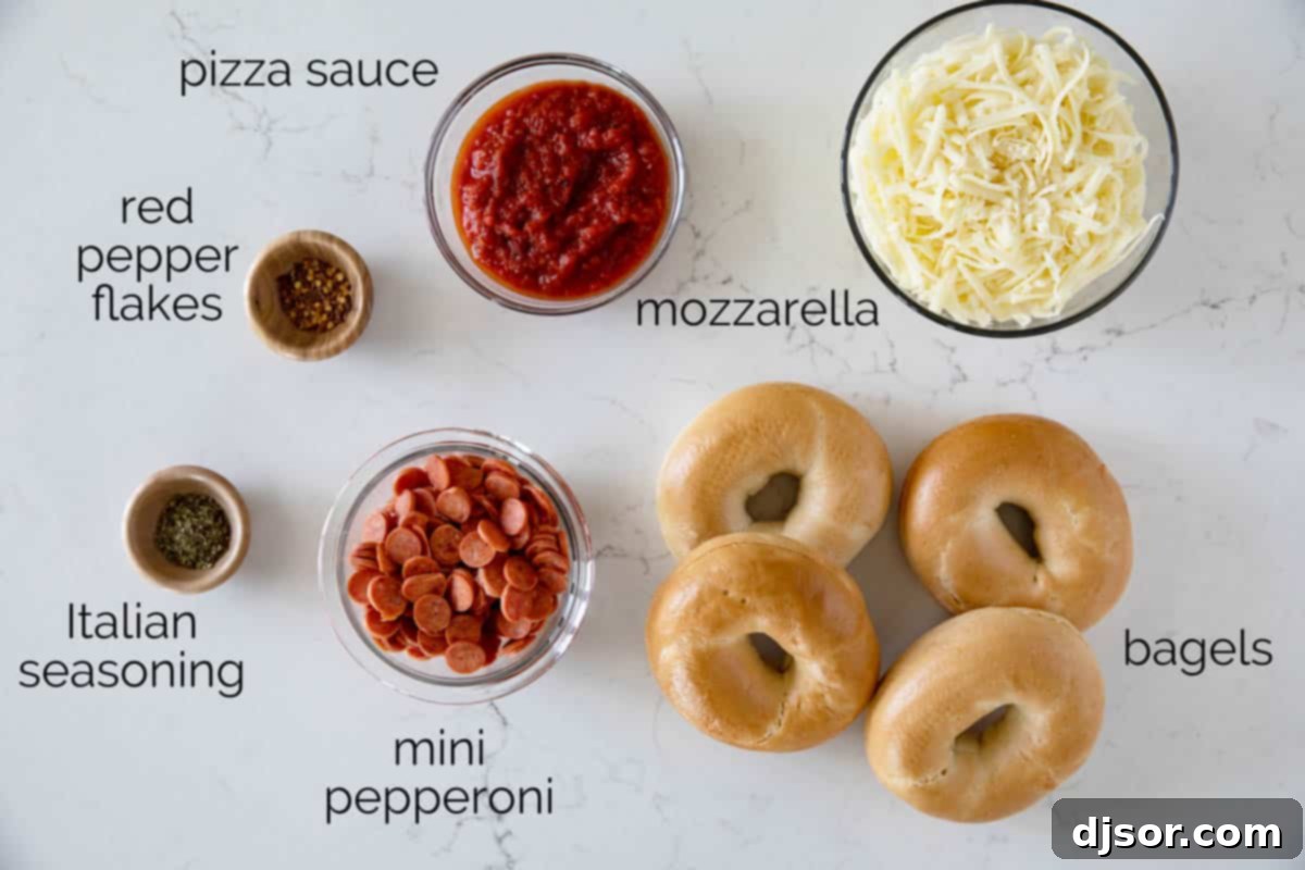 The Ultimate Bagel Pizza 3 A selection of fresh ingredients laid out on a cutting board, including bagels, pizza sauce, shredded mozzarella, and mini pepperoni, ready for making pizza bagels.