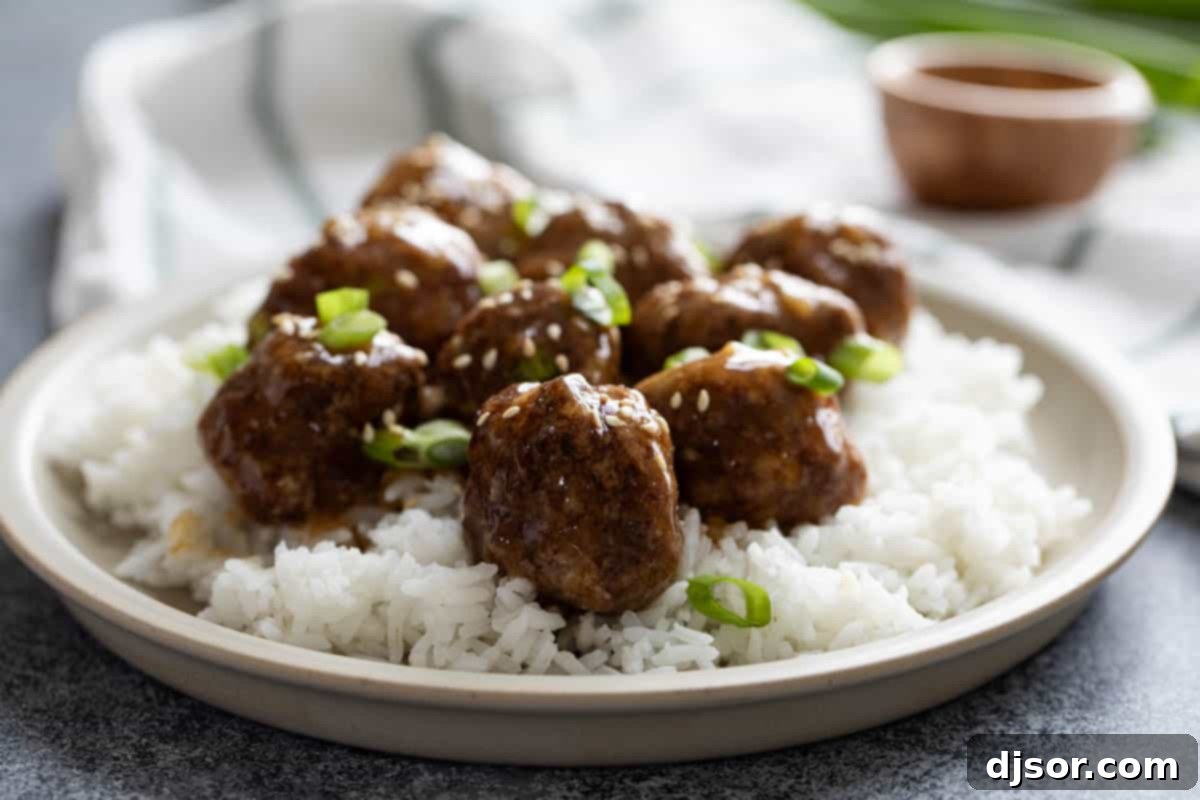 These Teriyaki Meatballs are made with a delicious homemade teriyaki sauce that is super easy and fast. The meatballs are juicy and flavorful, and the sauce is sweet, tangy, and savory. This recipe is perfect for a quick and easy weeknight dinner, or for a party appetizer. Plate with Teriyaki Meatballs on top of rice, then topped with green onions and toasted sesame seeds.