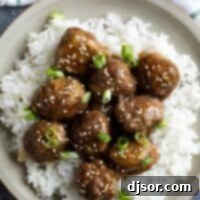 Sticky Teriyaki Meatballs 2 Plate with teriyaki meatballs on top of rice.