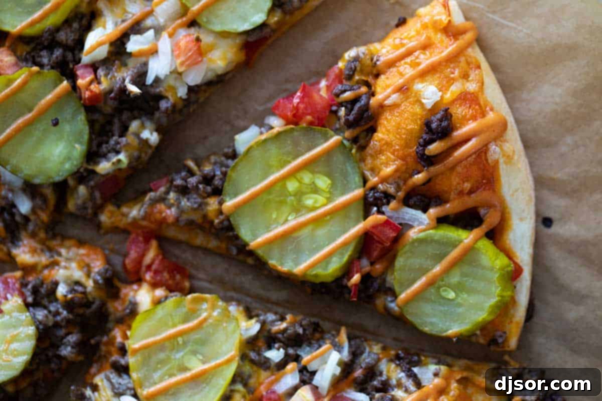 A perfectly baked slice of cheeseburger pizza, topped with rich burger sauce, ready to be enjoyed.