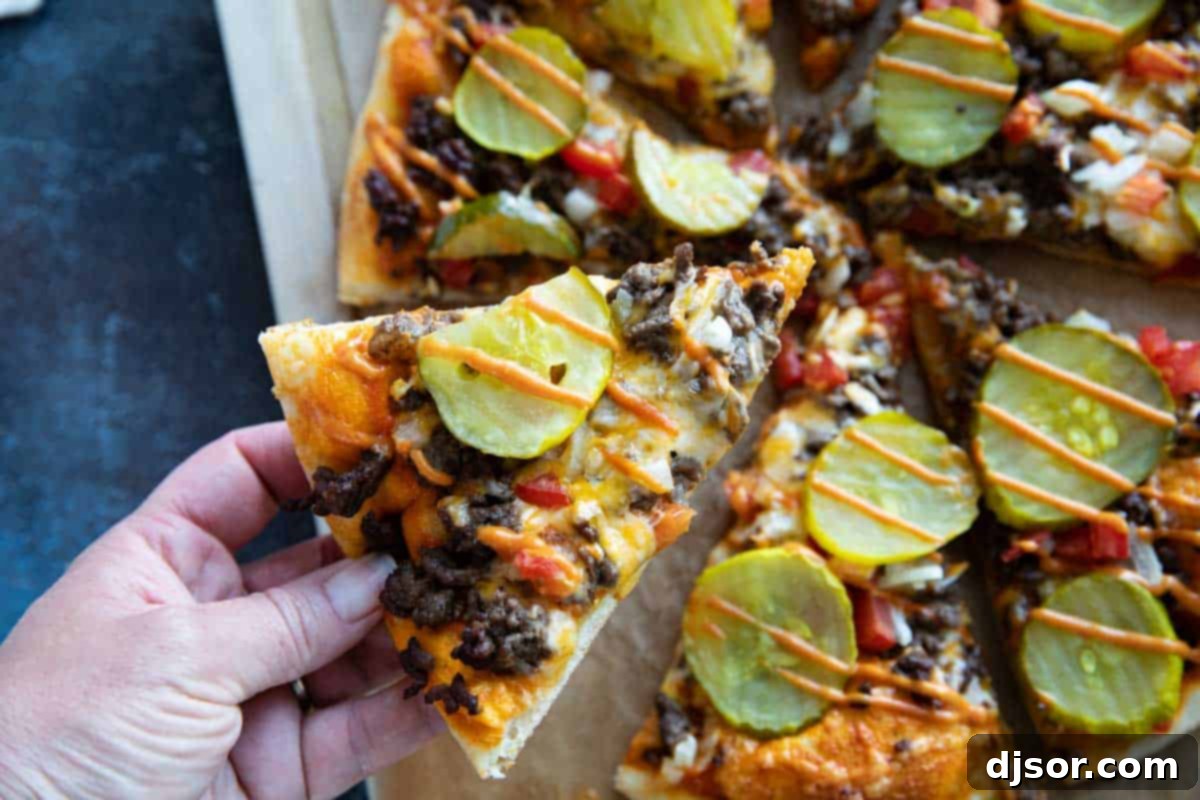 A hand reaching to grab a slice of freshly baked Cheeseburger Pizza, showcasing its delicious layers and golden crust.