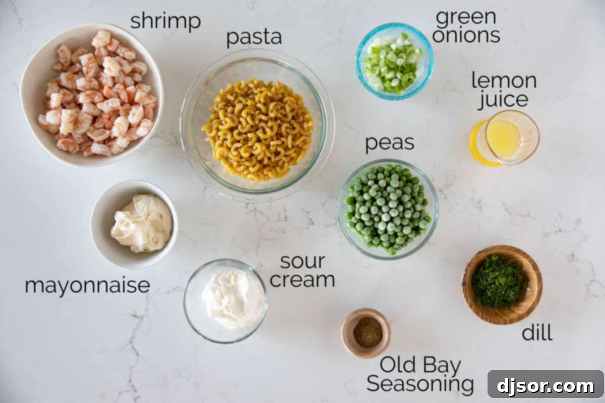 Various fresh ingredients laid out for making Shrimp Pasta Salad, including pasta, shrimp, vegetables, and dressing components.