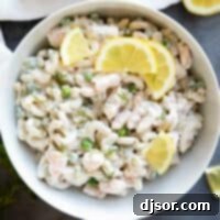 Bowl filled with Shrimp Pasta Salad topped with lemons and dill.