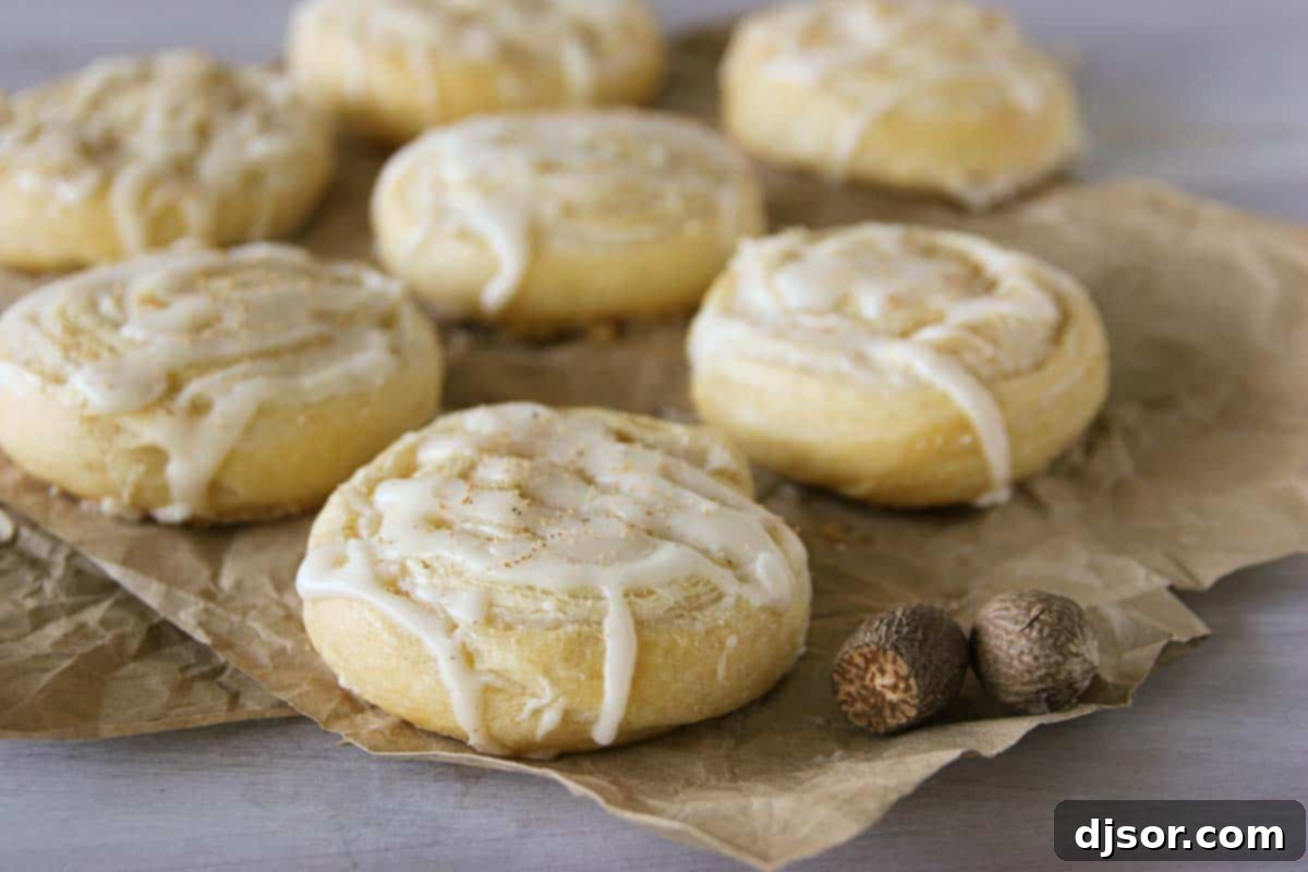 Spiced Eggnog Pinwheel Treats 2 Easy Eggnog Pinwheels with freshly grated nutmeg on the side, highlighting their golden brown crust and creamy filling