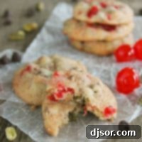 Cherry Chocolate Nut Cookie broken in half, sitting on another cookie.