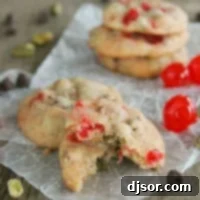Cherry Chocolate Nut Cookie broken in half, sitting on another cookie.