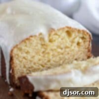 Beautifully baked Eggnog Bread with Eggnog Glaze, sliced and ready to serve on a rustic cutting board.