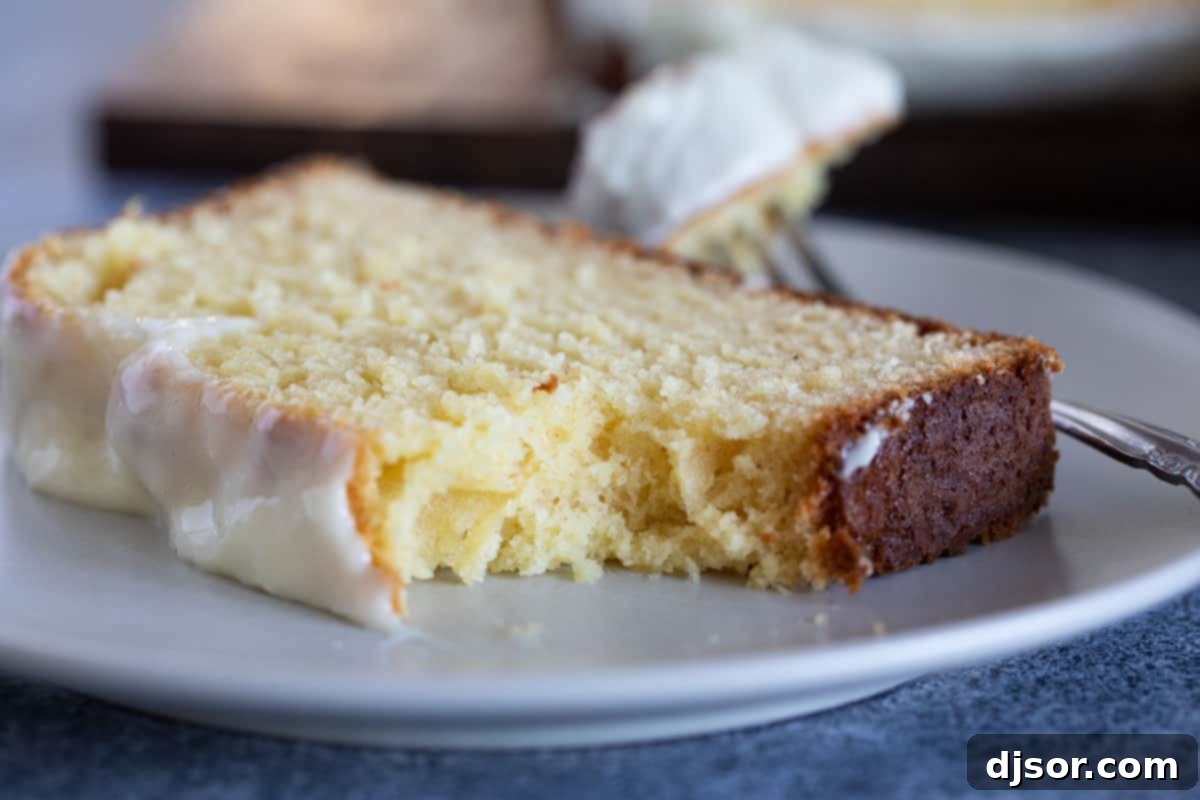 A delectable slice of Eggnog Bread with Eggnog Glaze, featuring a bite taken, highlighting its soft texture and the rich, creamy glaze.