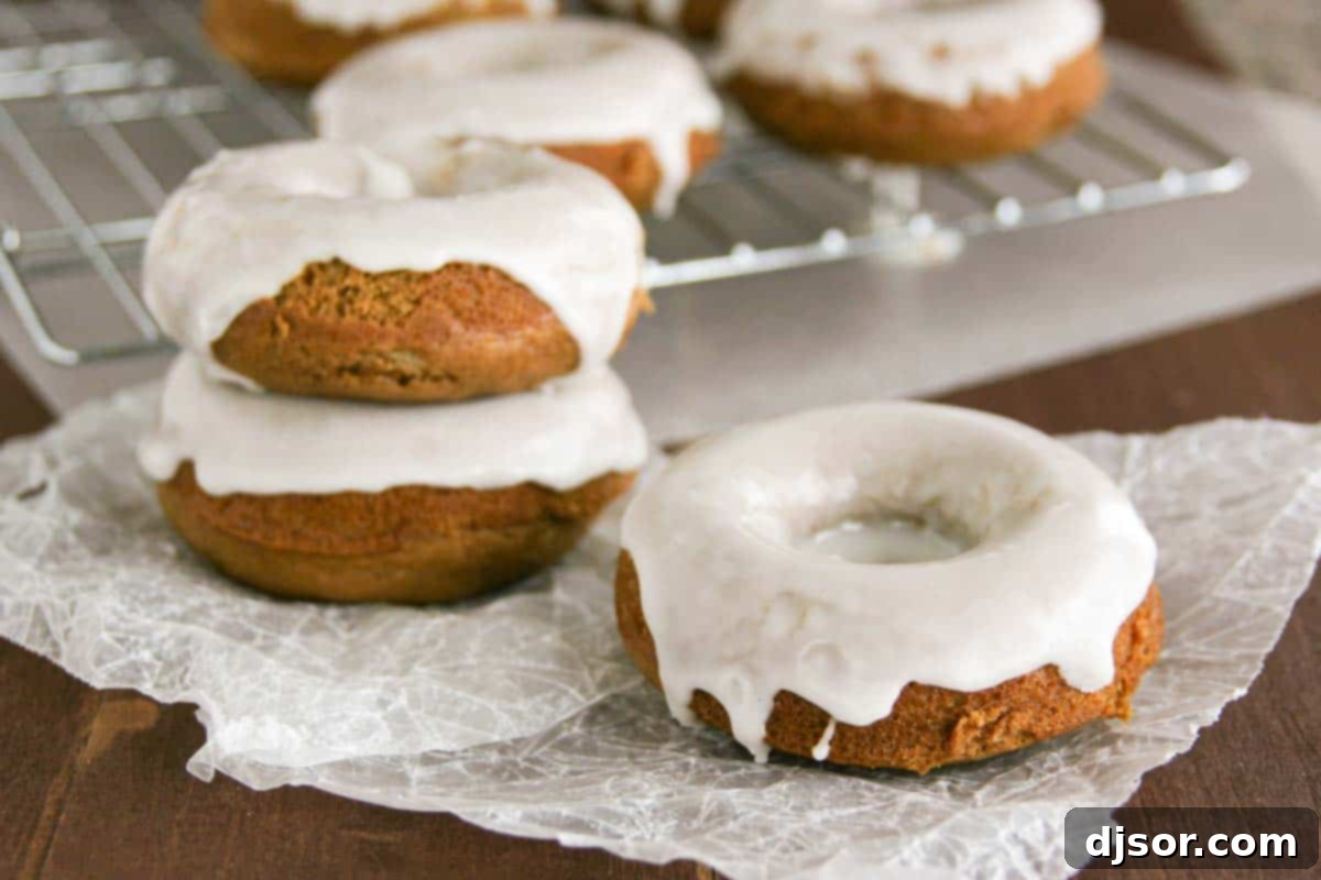 Glazed Gingerbread Baked Donuts on parchment with more behind