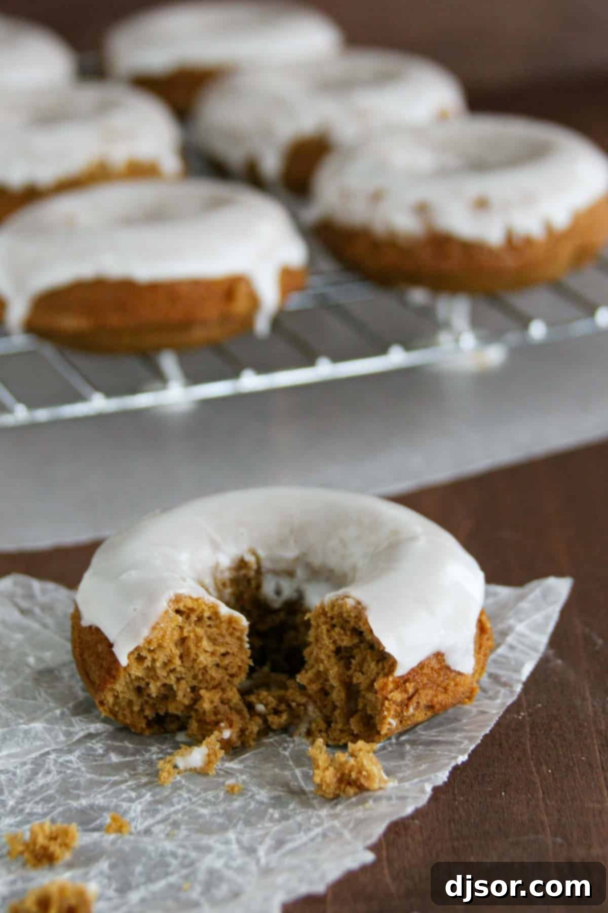 Glazed Gingerbread Baked Donuts with a bite taken from one donut.