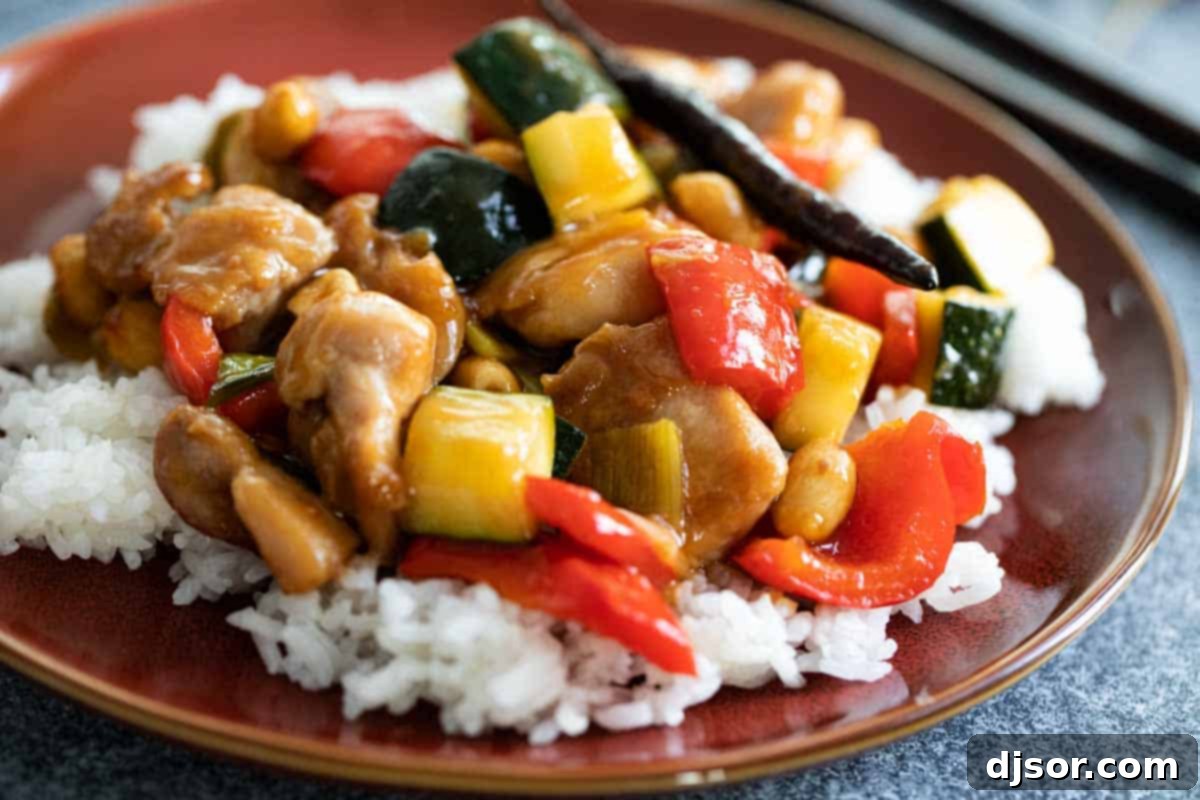 A plate of homemade Kung Pao Chicken served over fluffy white rice, ready to be enjoyed.