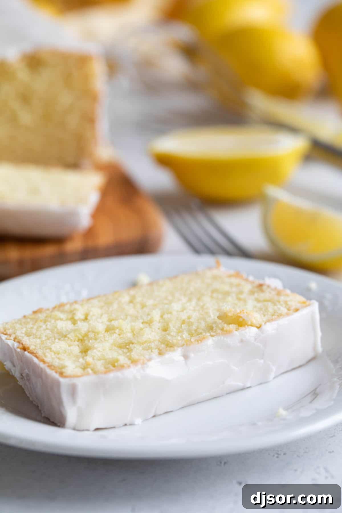 A perfect slice of iced Lemon Loaf on a plate Slice of iced Lemon Loaf on a plate.