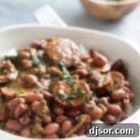 Andouille Red Beans and Rice 7 Bowl of rice topped with red beans and sausage, garnished with parsley.