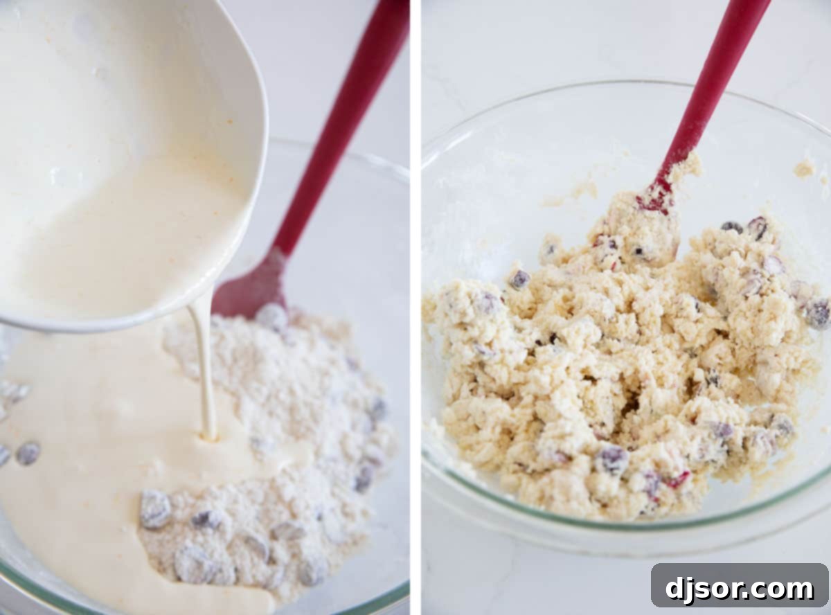 Close-up of scone dough being gently mixed in a bowl, showing a shaggy consistency.