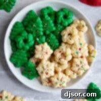 Homemade Spritz Cookies A Step-by-Step Guide 9 Plain and green Christmas Spritz Cookies on a plate with more cookies around the plate.