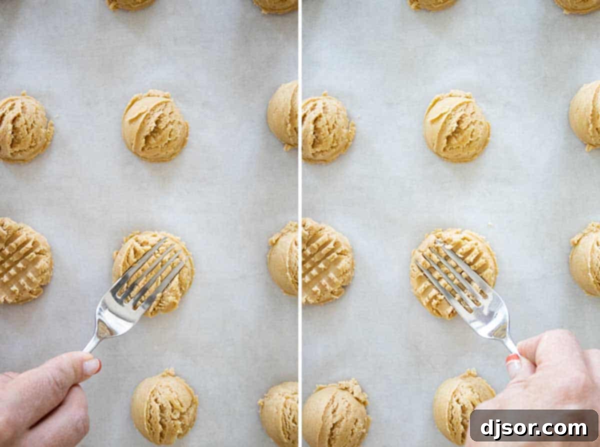 A close-up of cookie dough balls, perfectly rolled and ready, being pressed with a fork to create the classic criss-cross pattern before baking into soft peanut butter cookies.