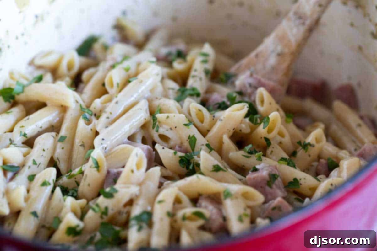 Finished Ham and Cheese Pasta with Ranch Close-up of creamy pasta with ham and ranch seasoning, garnished with fresh parsley