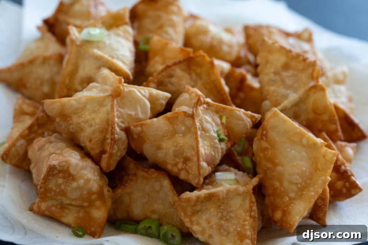 Crab Rangoon on a plate with green onions.