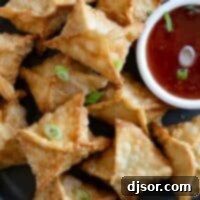 Plate filled with crab rangoon with a bowl of sweet chili sauce.