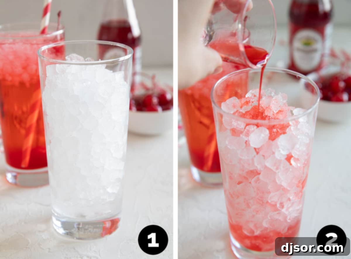 A glass filled with ice, with grenadine being poured into it, creating a beautiful red layer at the bottom.