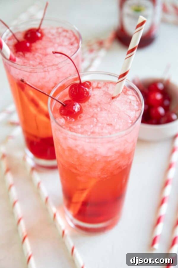 Multiple glasses of Shirley Temples, garnished with bright maraschino cherries, perfectly arranged for a celebration or gathering.