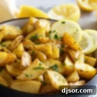Zesty Greek Lemon Potatoes 8 Bowl filled with roasted Greek Lemon Potatoes with lemon slices in the bowl.
