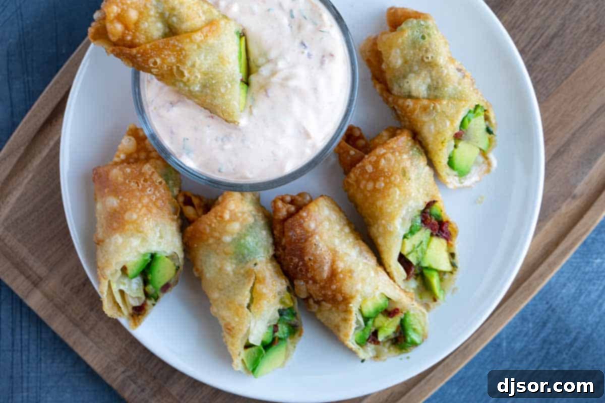 Halved crispy avocado egg rolls on a serving platter